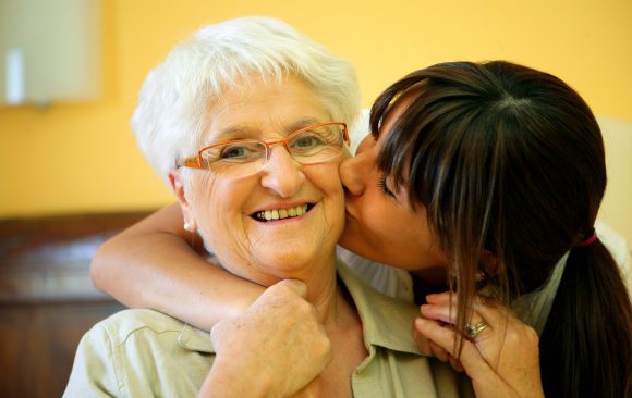 Reunite_Young Woman Kiss Senior Woman on Cheek Seniors