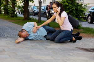 Medical Emergency_Woman on Phone with Man in Recovery Position